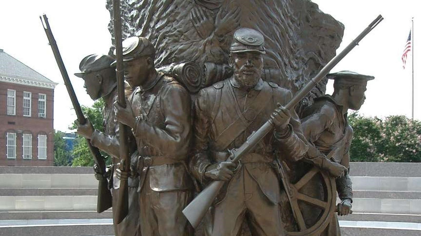 One side of sculpture with four soldiers.