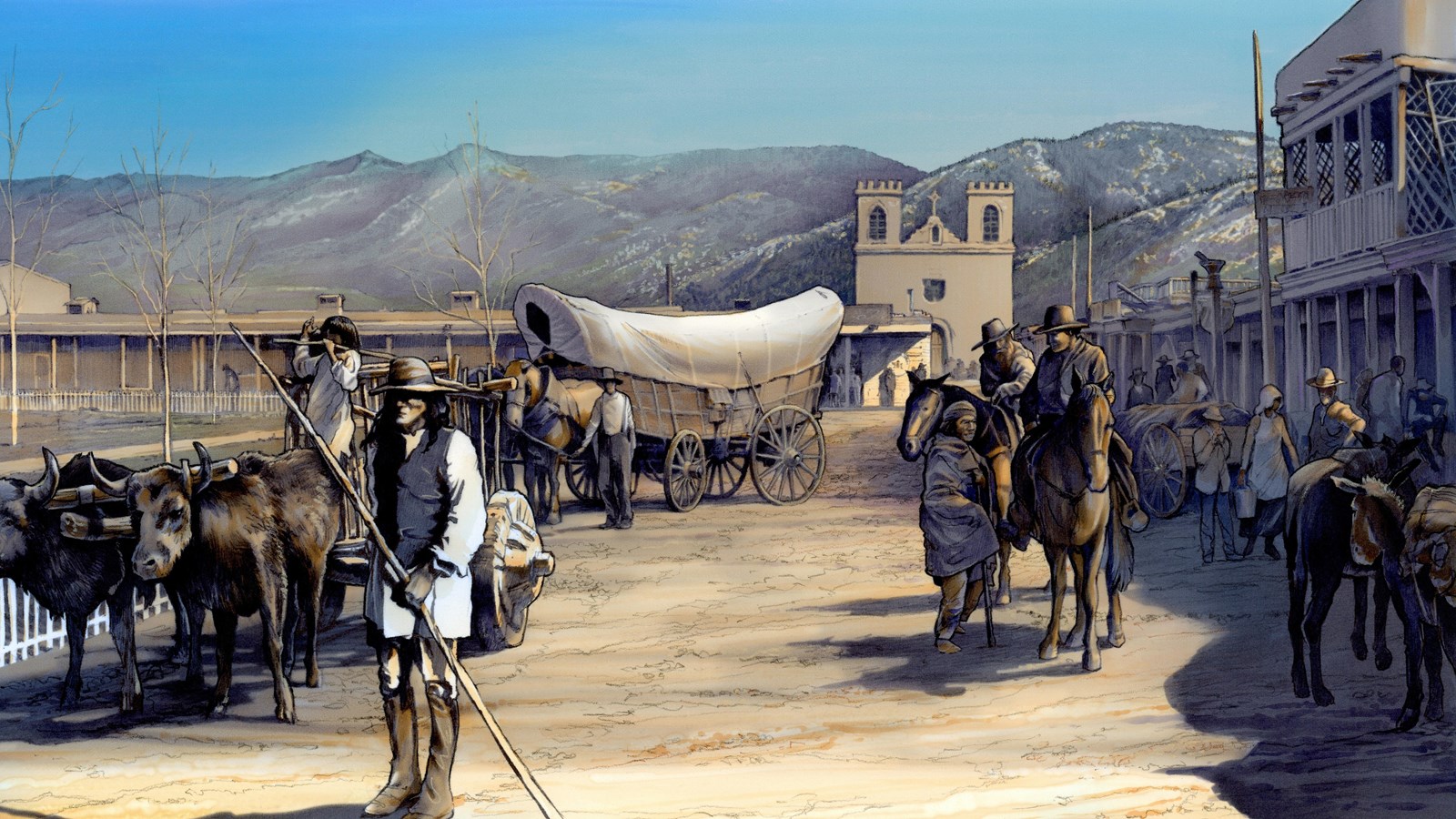 Men, wagons, oxen, travel down a historic dirt road in a historic town plaza.