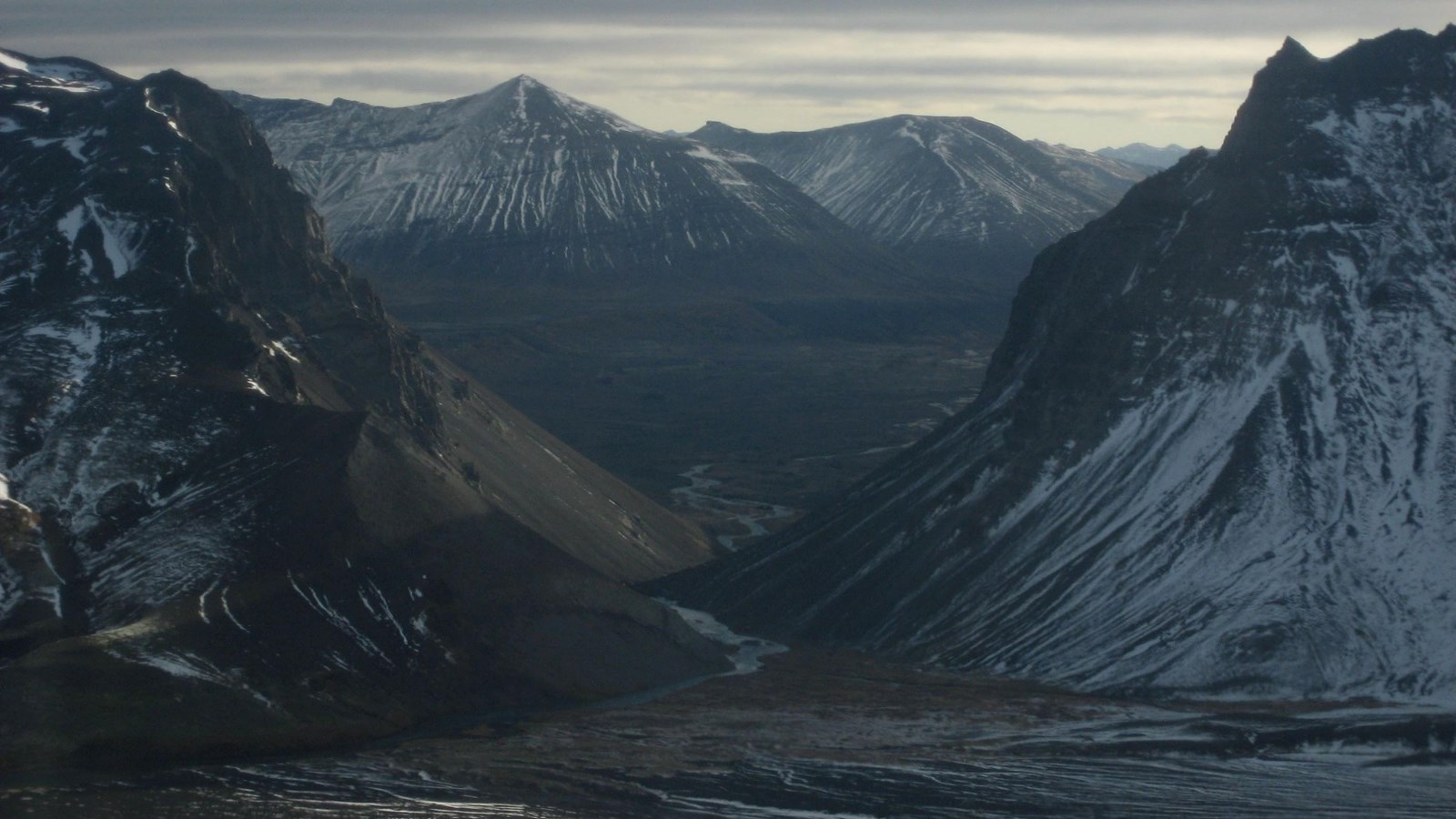 A river flowing through a v-shaped notch with tall land formations rising on either side