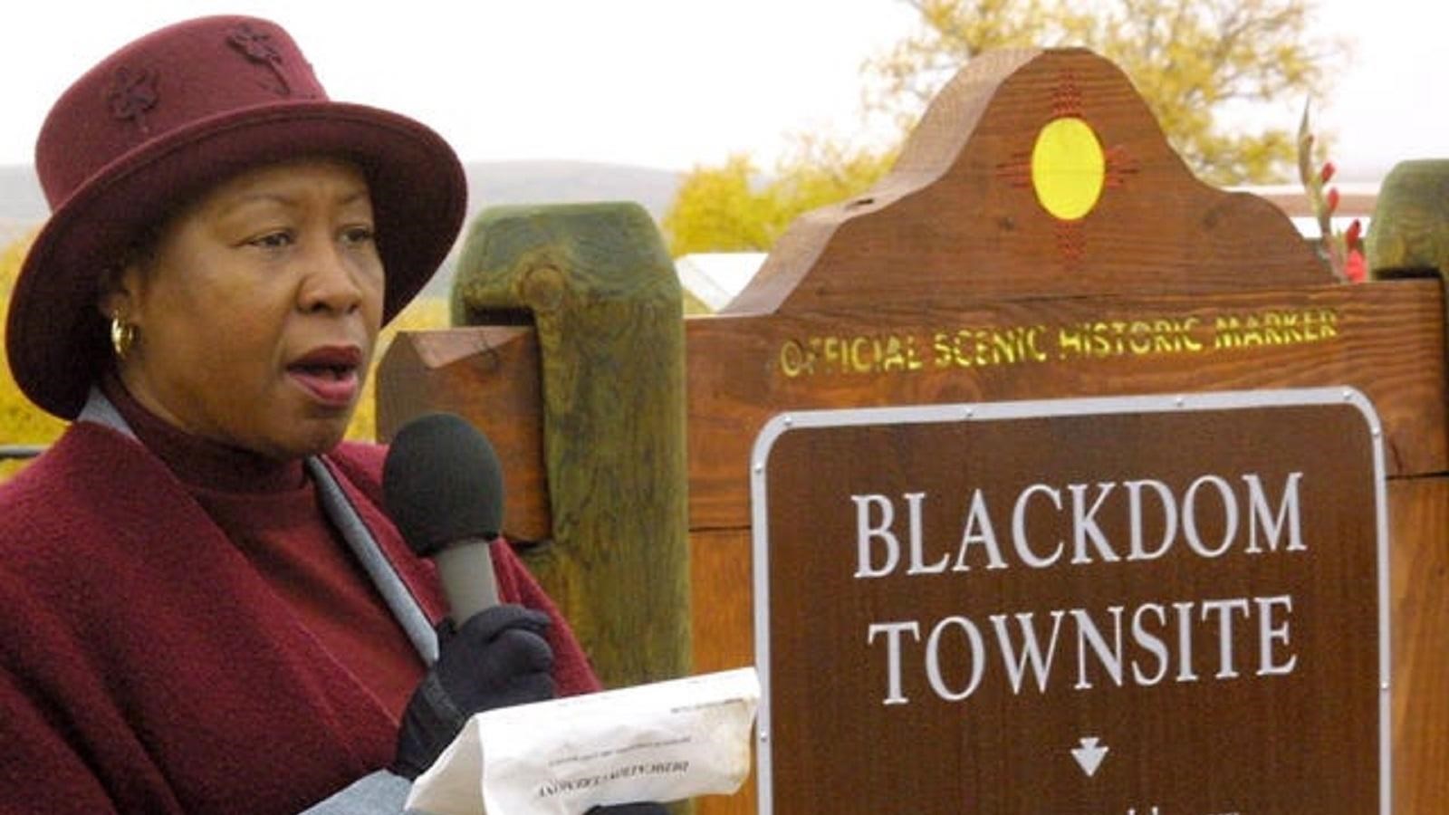 Woman with a microphone standing next to a 