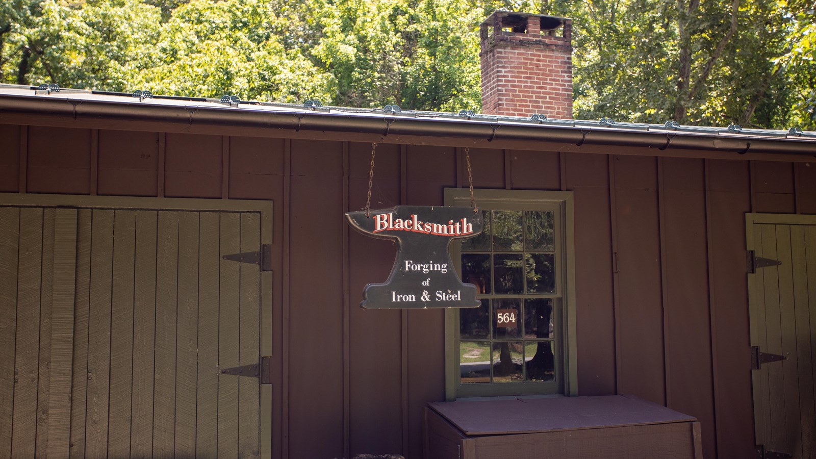 A dark brown building with an anvil-shaped sign