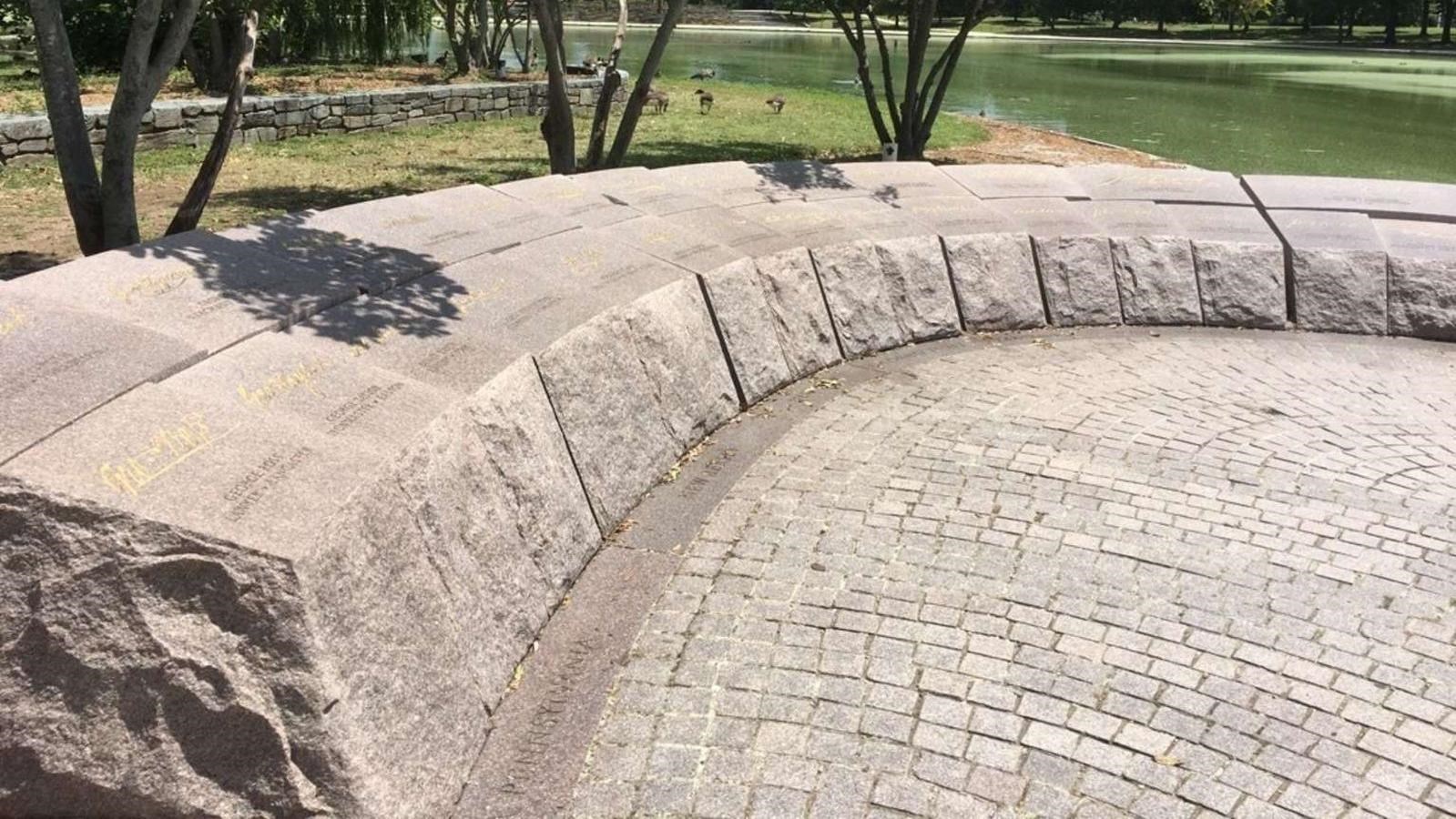 Low, curving, stone monument with names inscribed.