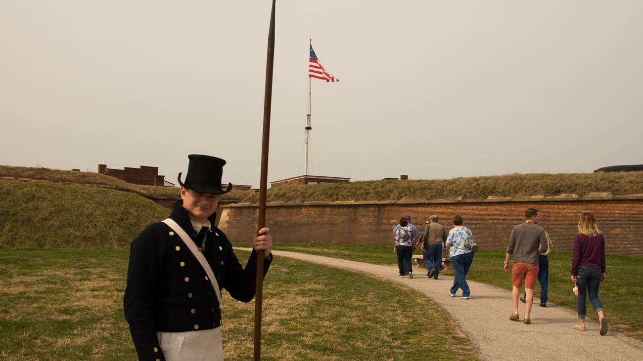 A living historian greets visitors at the entrance of the historic zone.