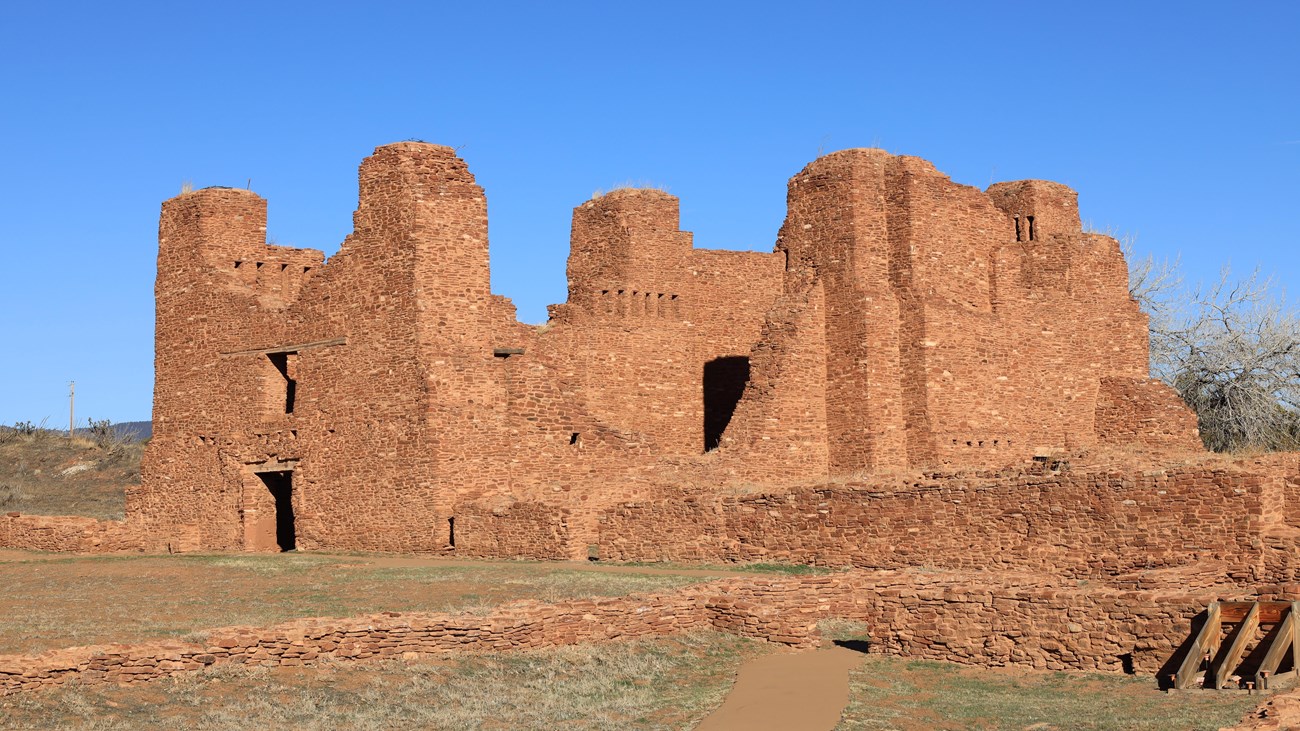 Red sandstone church remnants against a blue sky background.