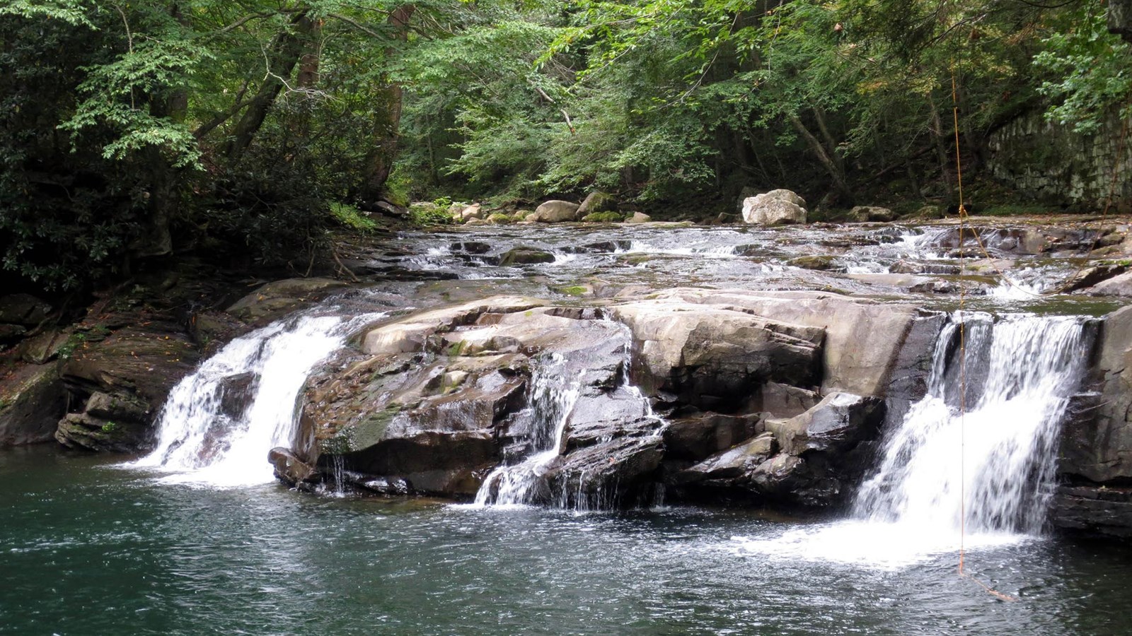 A view of a waterfall into a deep pool along the trail. 