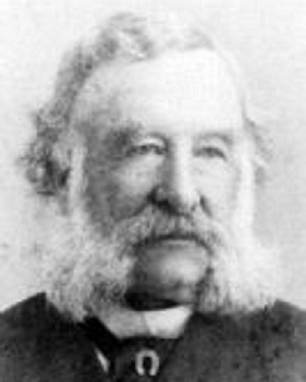A portrait of an older man with long sideburns and beard with a black suit on.
