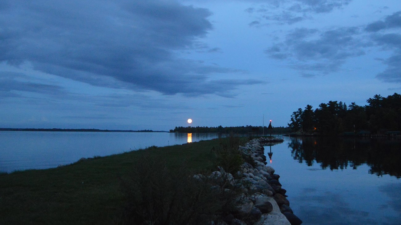 The moon rises over Lake Kabetogama with a jetty in the foreground