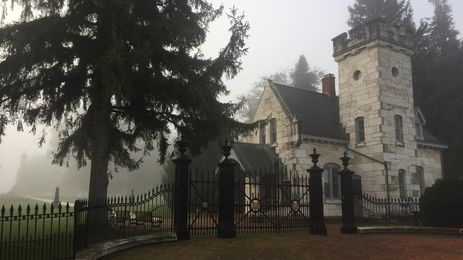 light color stone building inside black iron fence