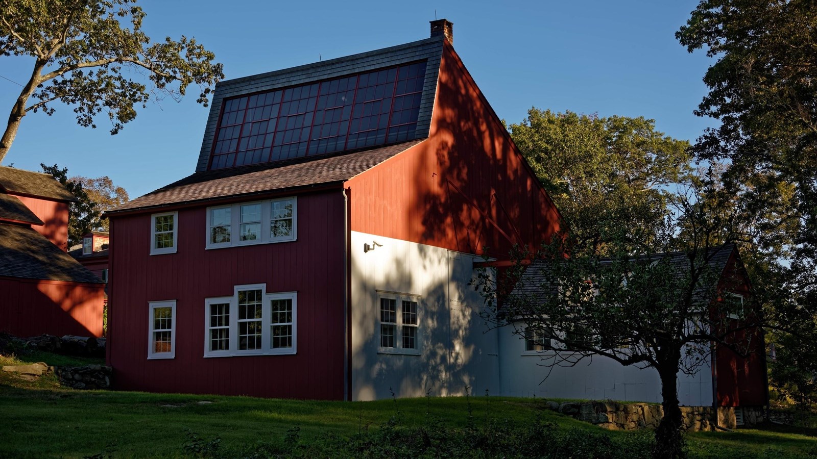 A red building with a wall of windows with white trim.