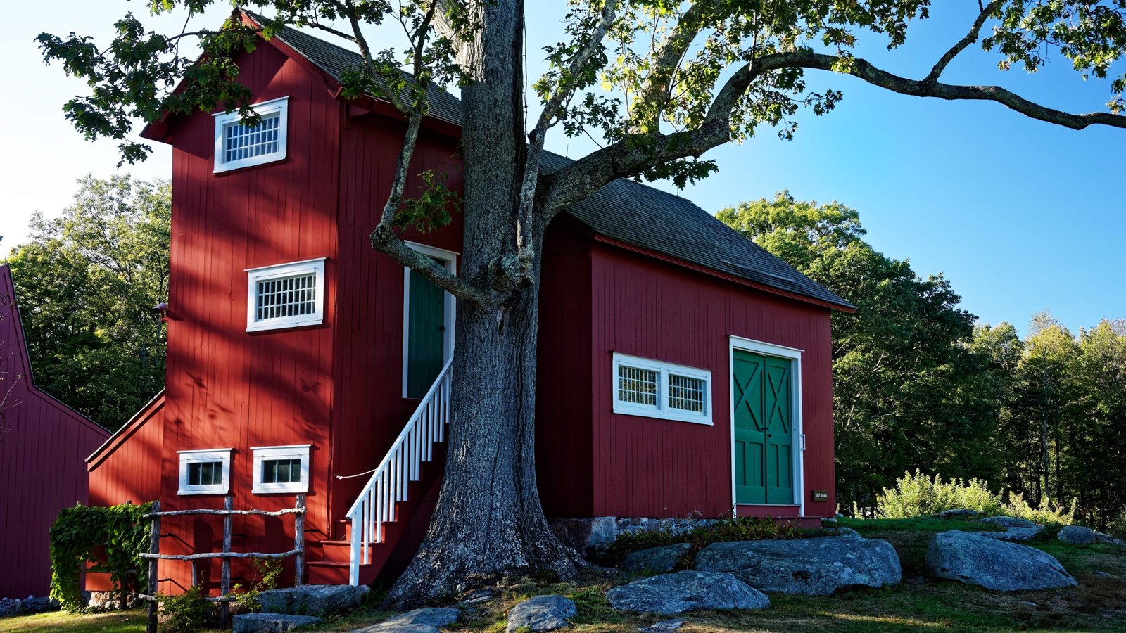 A red building with a green door and white trim.