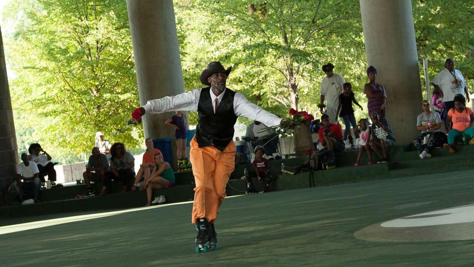 A visitor dressed in 1970s attire skates in the pavilion. 