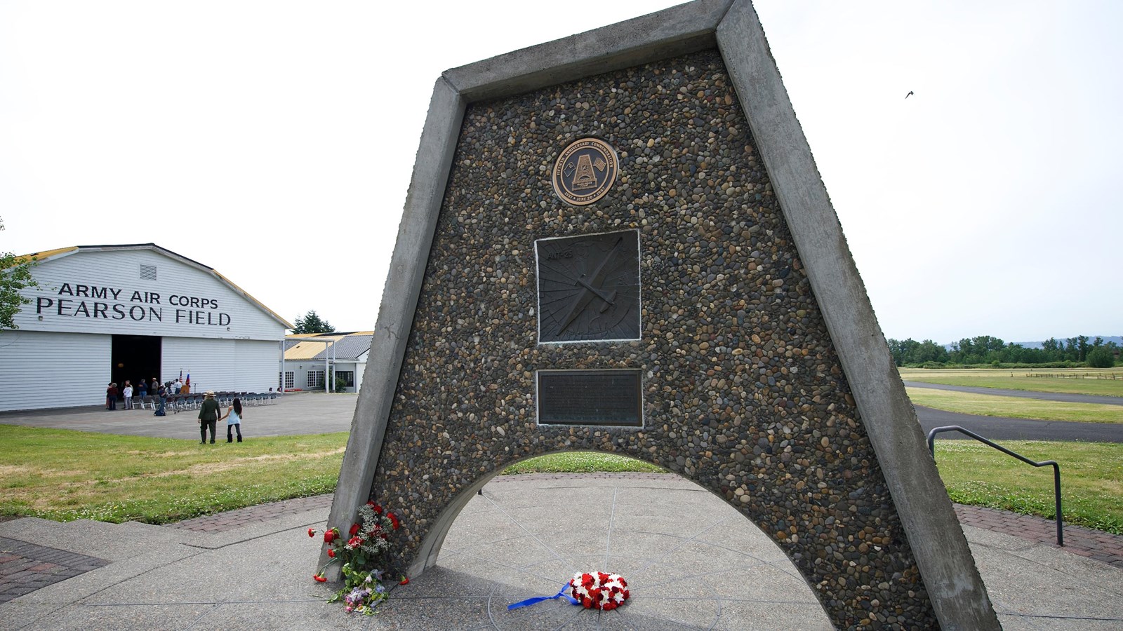 A triangular metal and stone monument with Pearson Air Museum in the background.