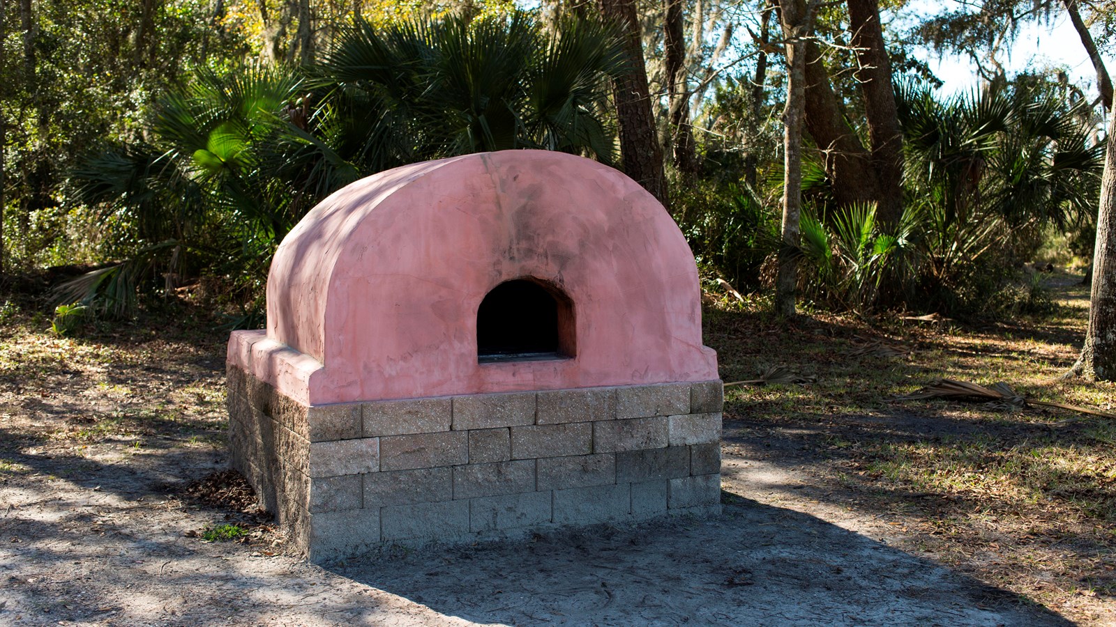 a rusty red mud domed oven
