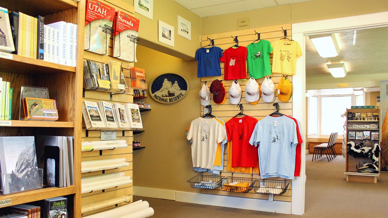 Retail area with books, maps, hats, and shirts lining the walls.