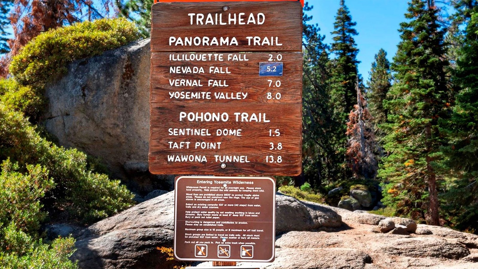 Wooden and metal signs at the trailhead