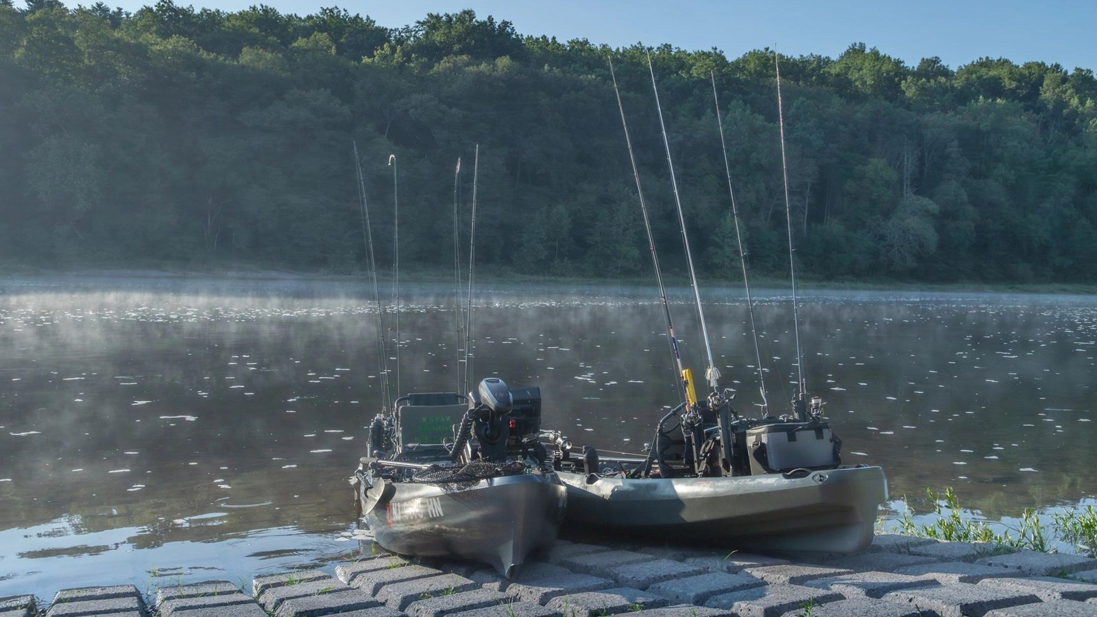 Two fishing kayaks loaded with poles and gear wait on the boat launch at Dingmans Access.