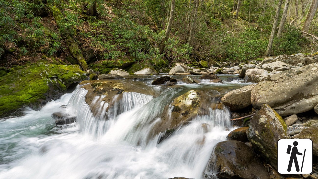 A small cascading waterfall on rocks in a stream. 
