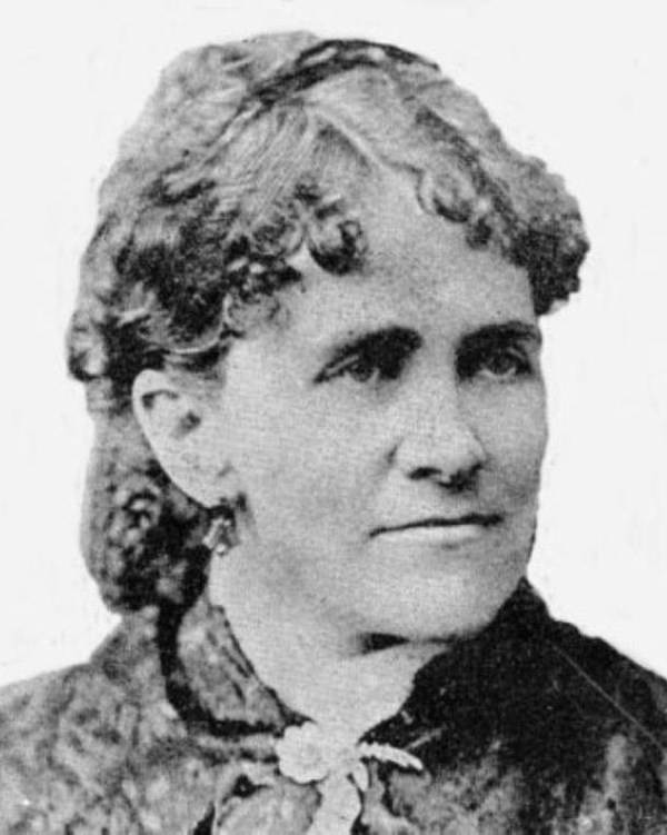 A woman with curls and a dark jacket.