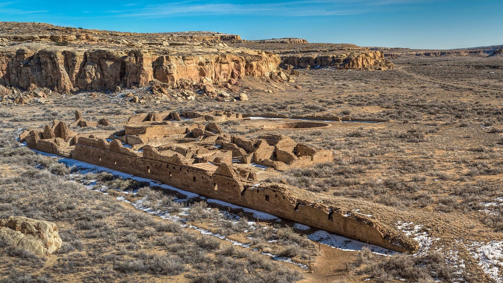 The remnants of the Chetro Ketl great house seen from a high angle taken on top of a mesa. A long wa