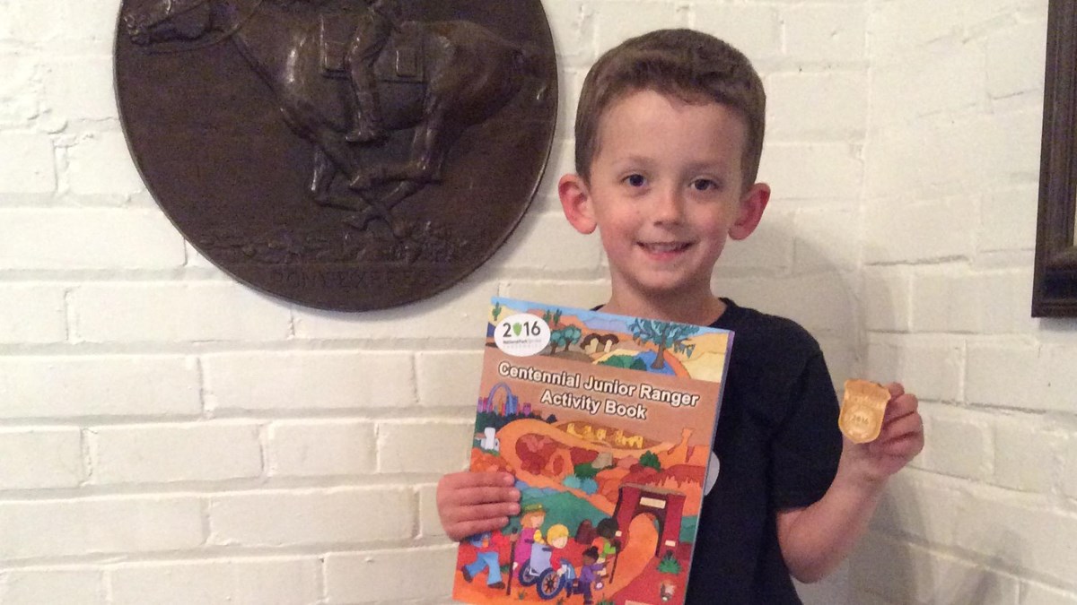A Junior Ranger proudly shows off his badge.