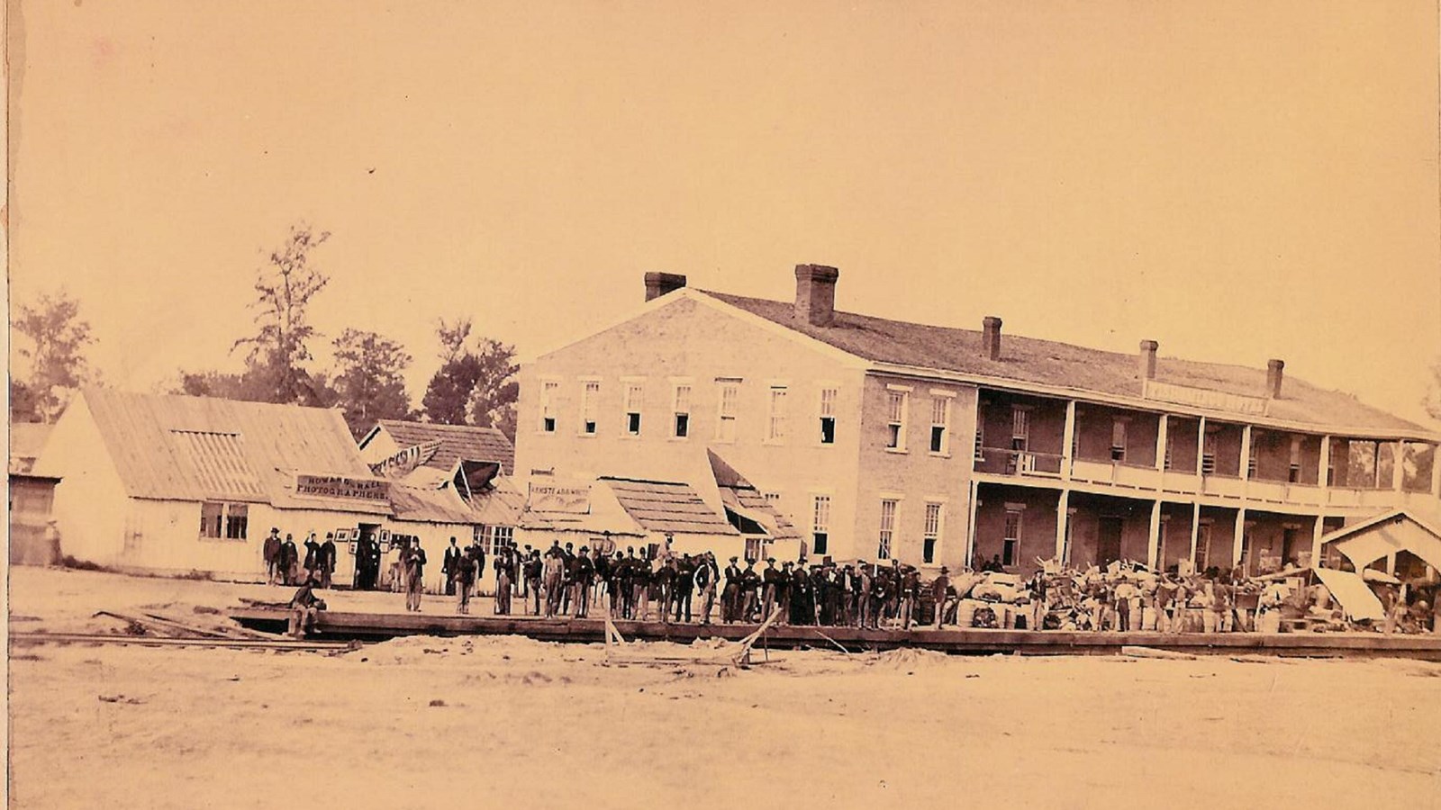 Historic image of a two-story building with people standing in foreground