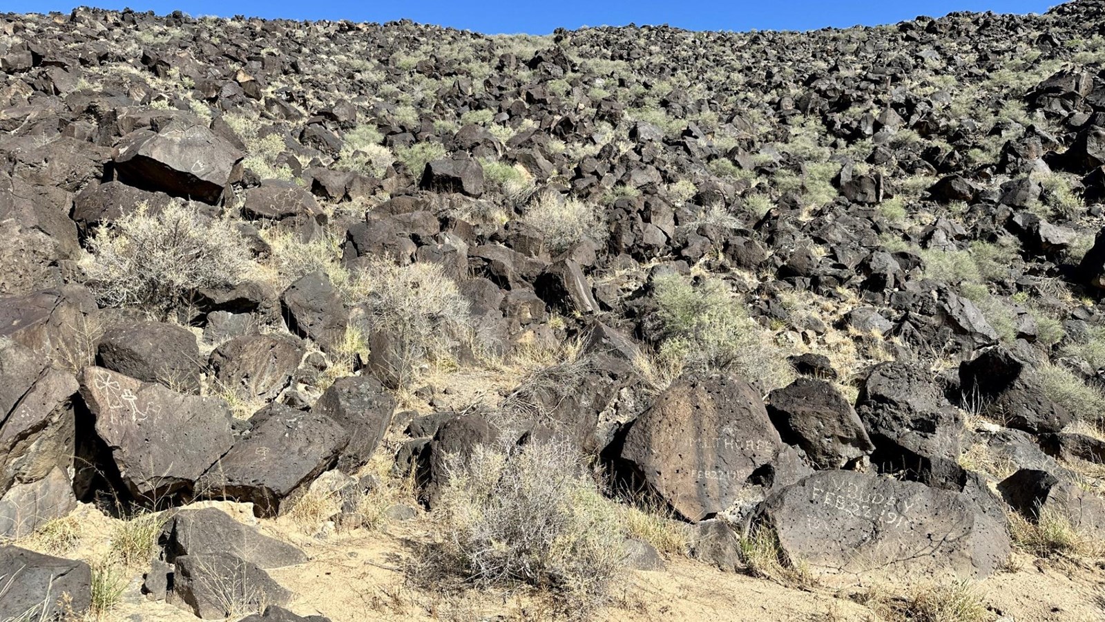 A volcanic landscape under a blue sky.