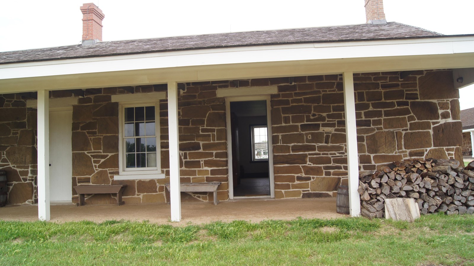 Portion of a one-story sandstone block building with overhanging roof.