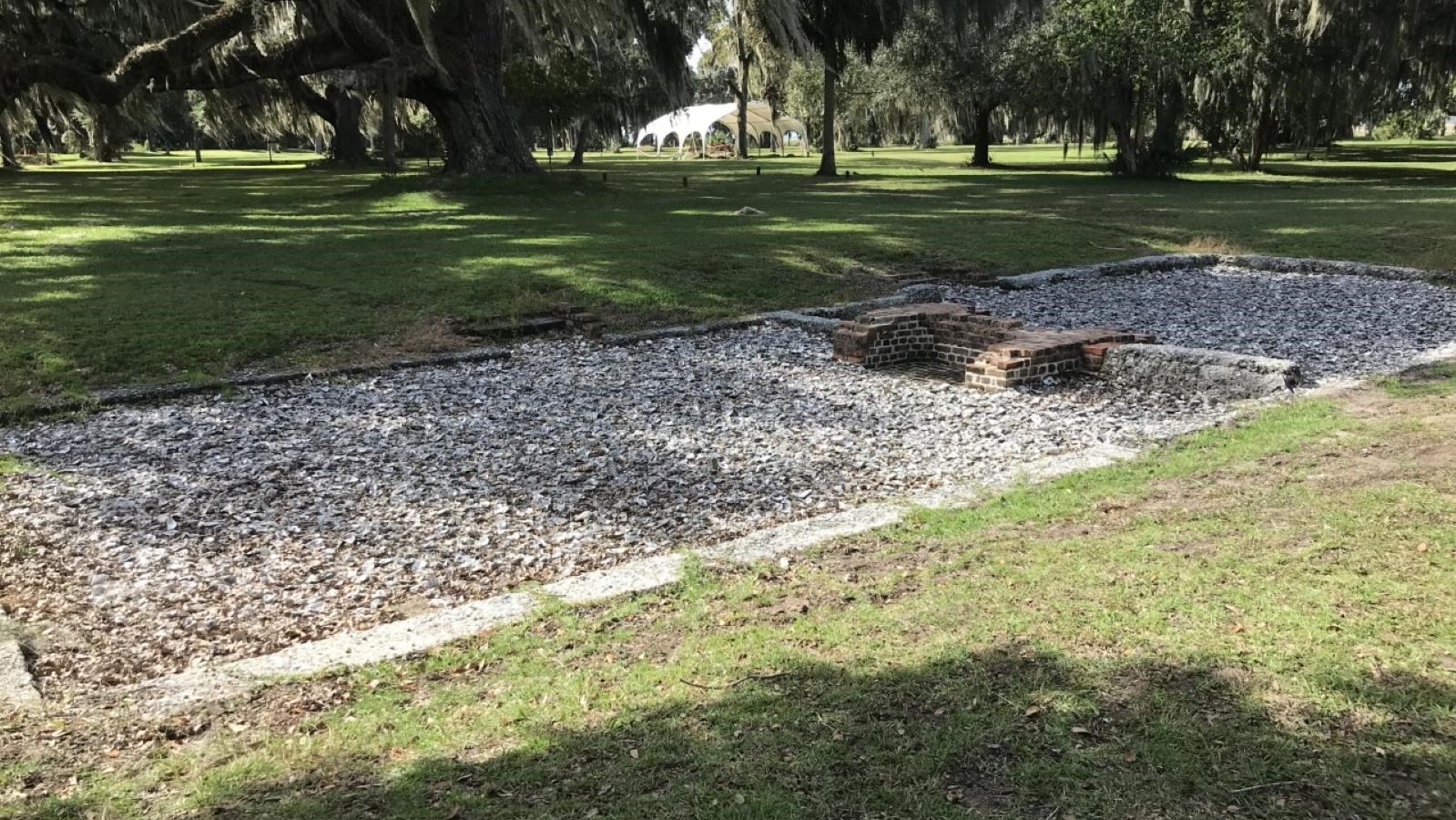 Tabby foundation ruins with brick fireplace remnants in center, oyster shells in interior floor.
