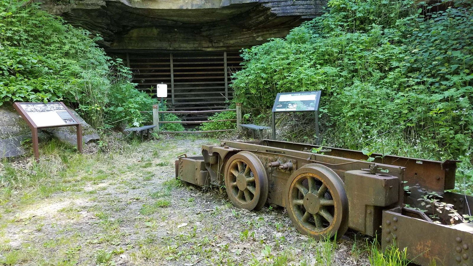 A mine car ruin sits in front of the mine entrance