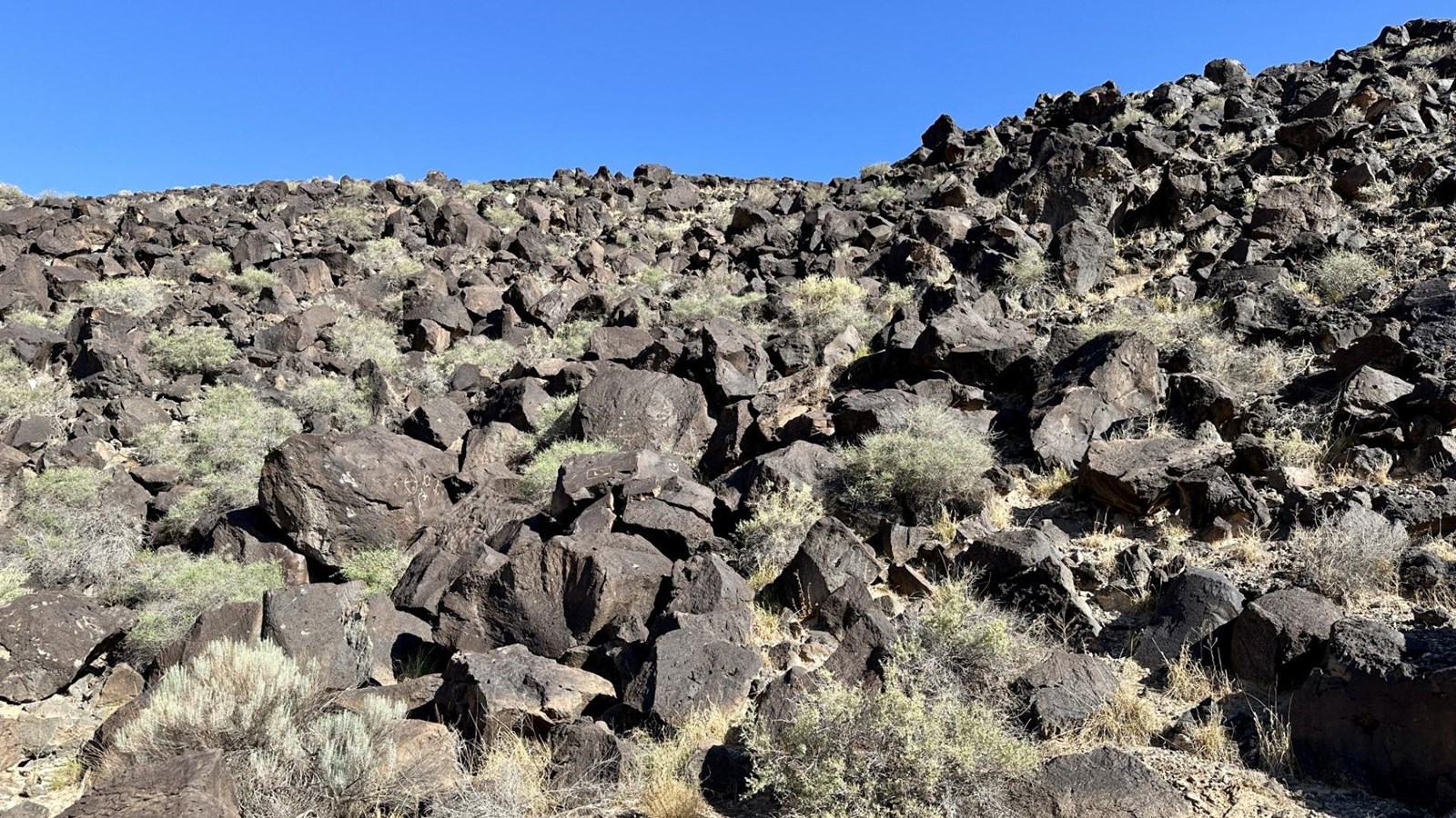 A volcanic landscape under a blue sky.