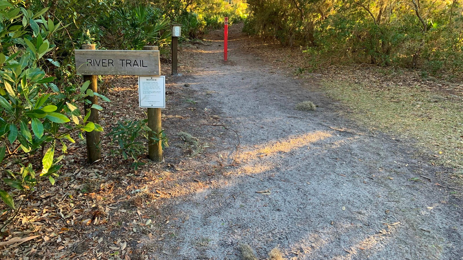 A red sign marks the beginning of the river trail.