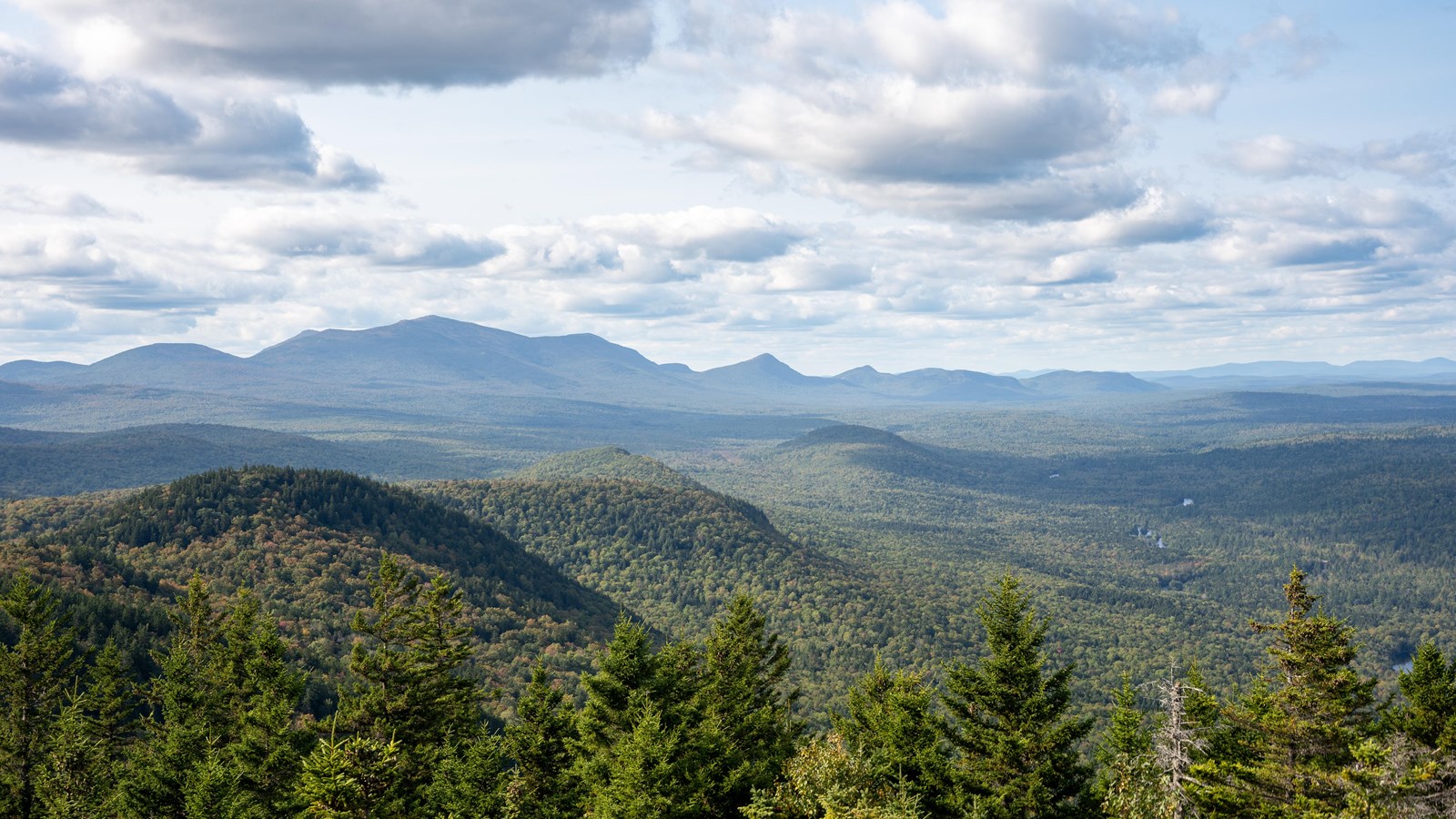 A mountain top lookout with many rolling green mountains in the distance