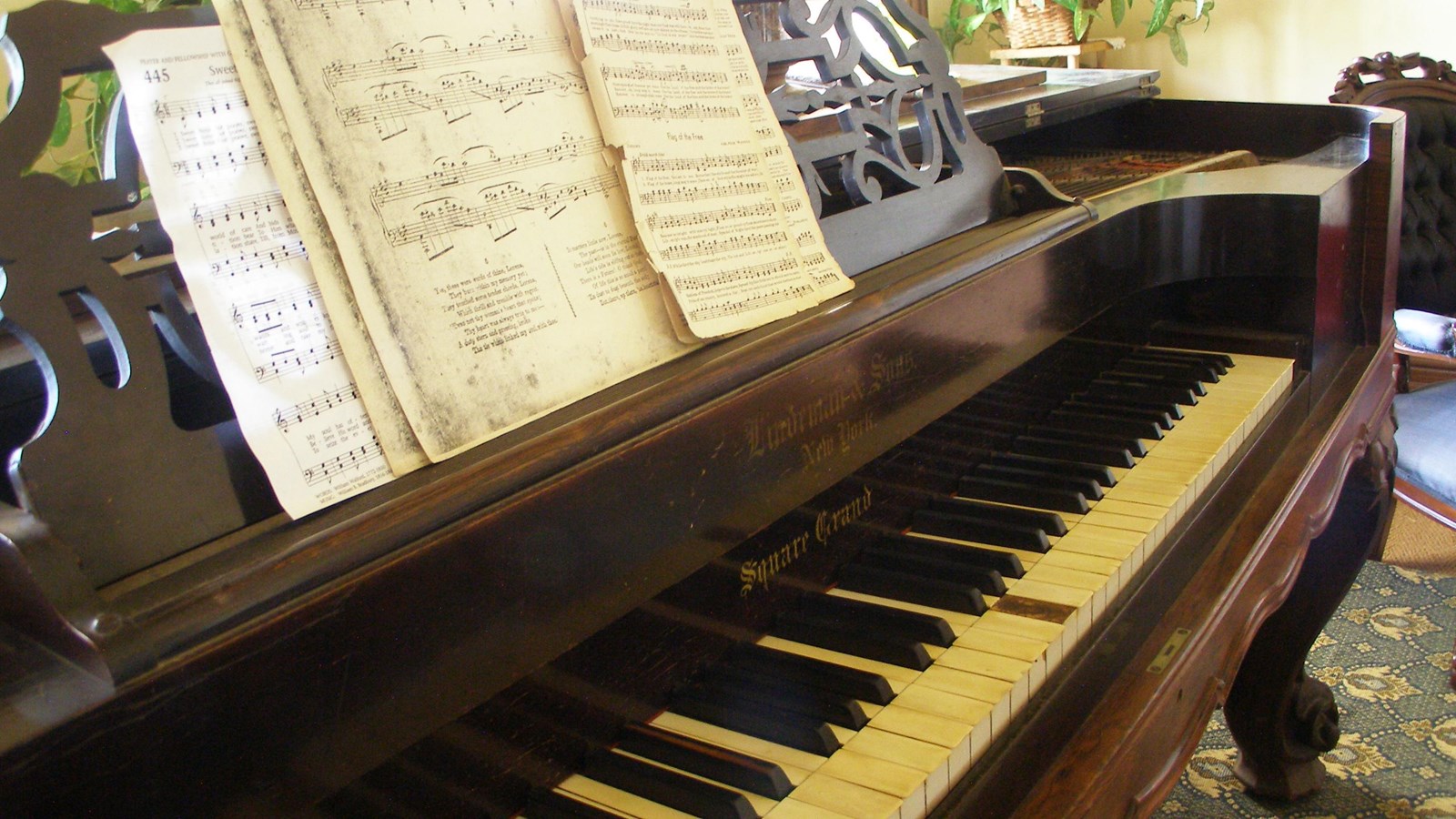 Close up view of piano showing keys and sheet music above them. 