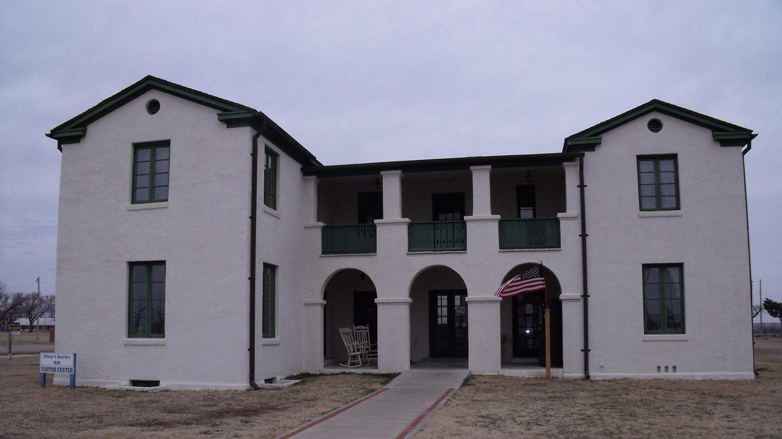 A two story white building with black trim and large windows.