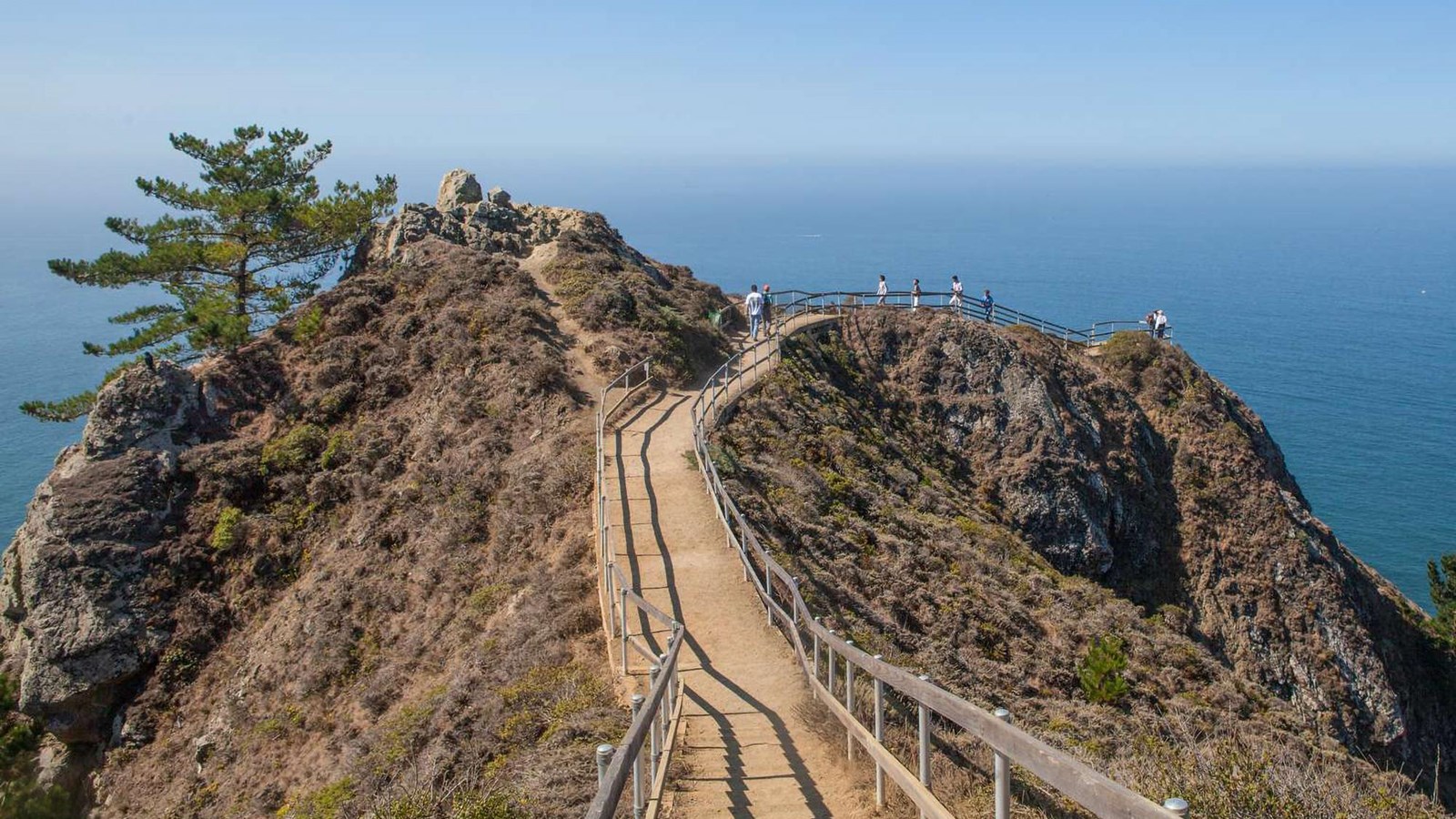 Stairs along a ridge, down to the Muir Beach Overlook, the ocean is seen in the distance.
