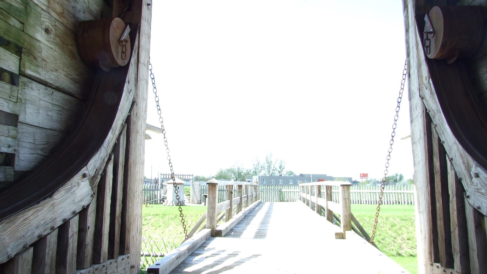 You see two chains running vertically from large metal wheels and fastened to a wooden bridge.  