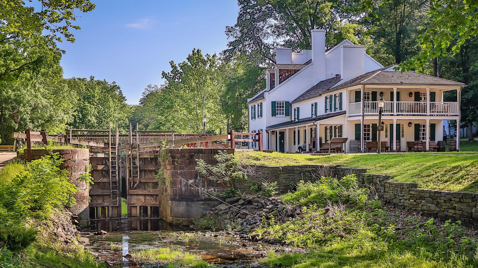 A large lock sits next to a large white tavern.