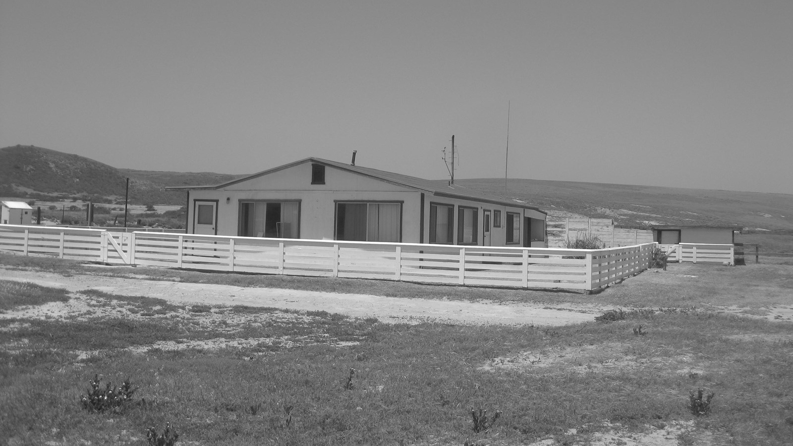 One story white building with picket fence around it. 