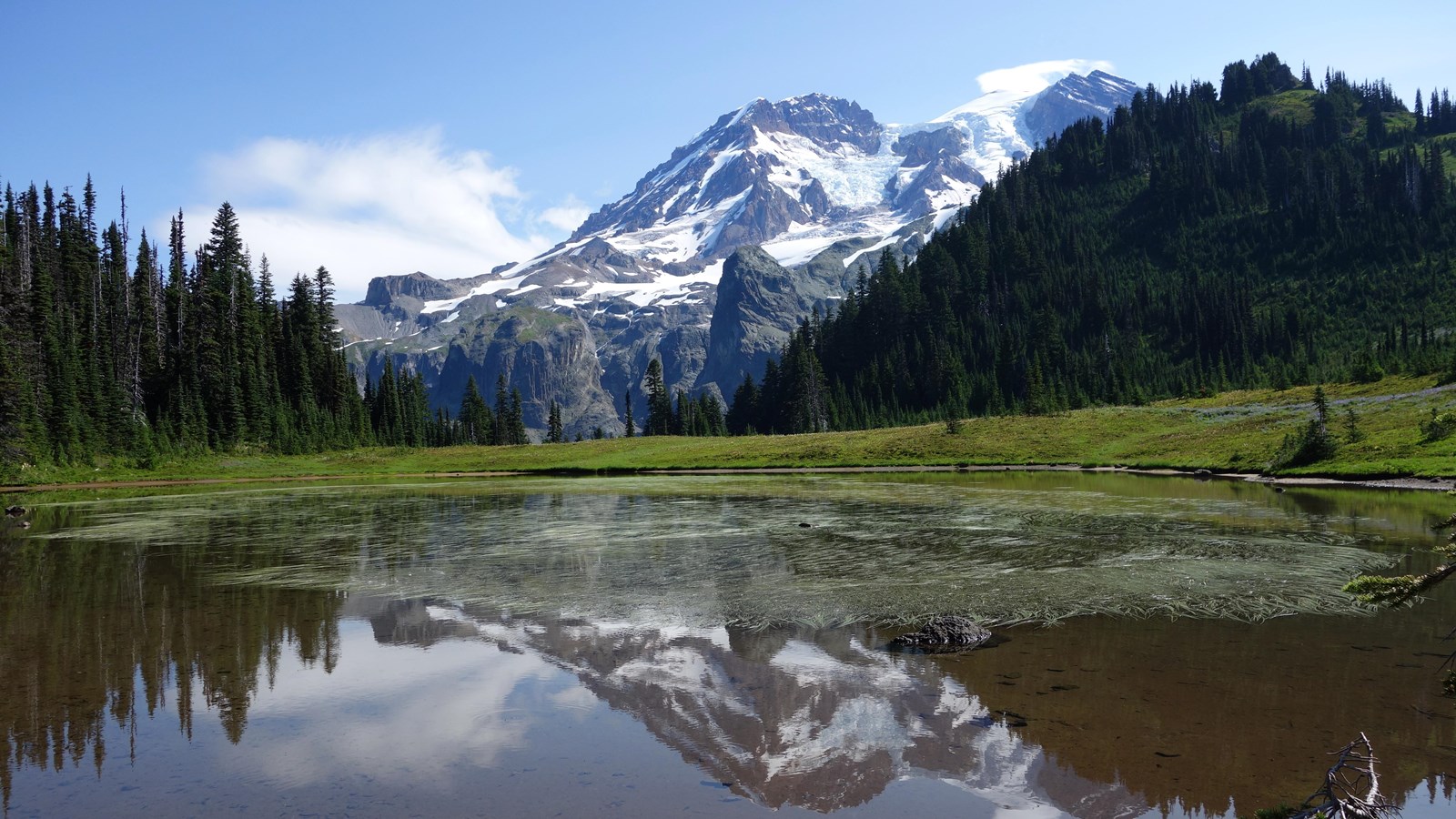 Hanging valley glacier on rock above lake