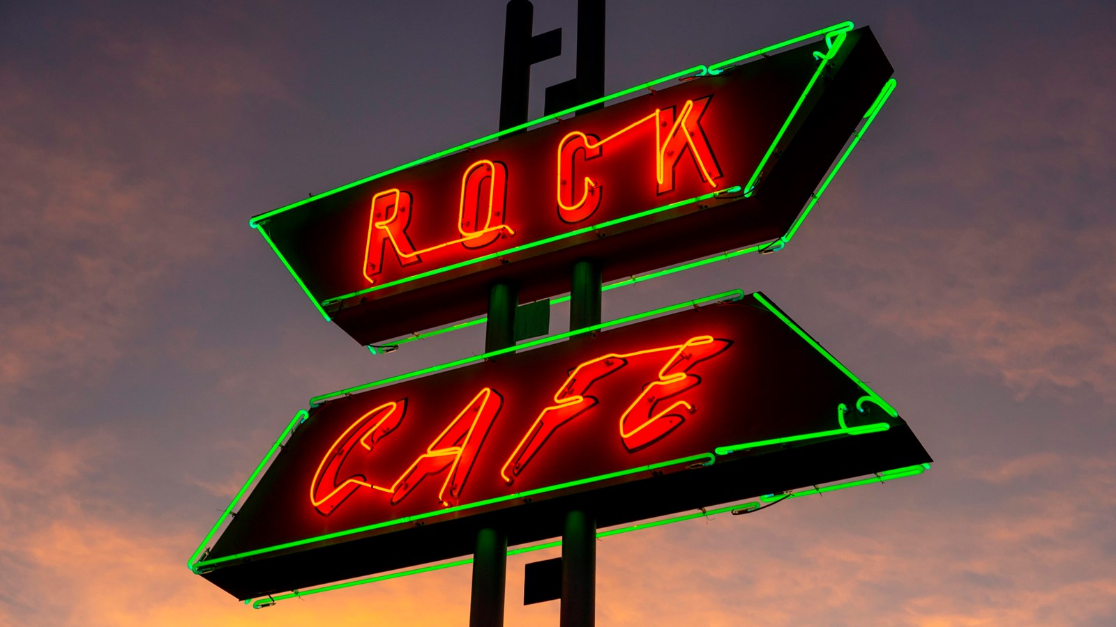 A sign at night reads