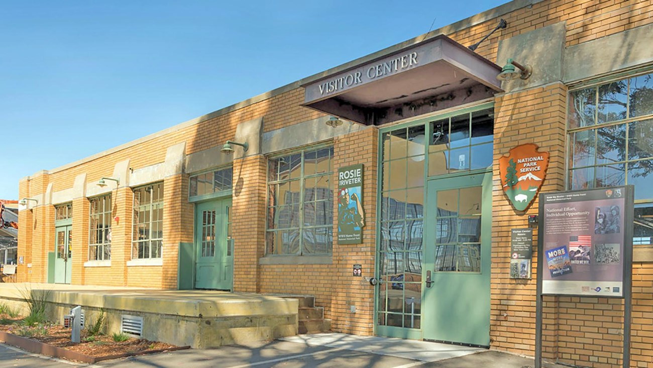 Front of Visitor Education Center building. Brick building with multiple glass windows. 