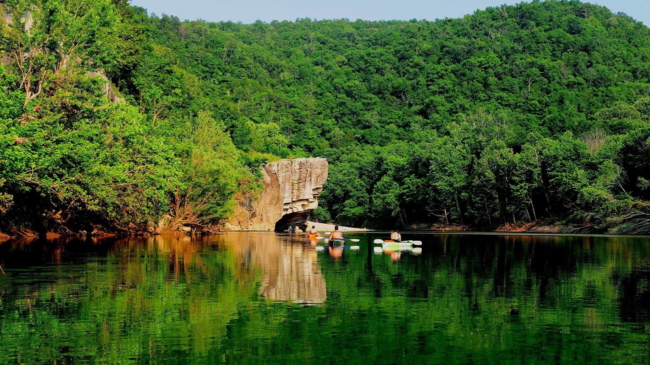 Several kayakers paddle towards Skull Rock.