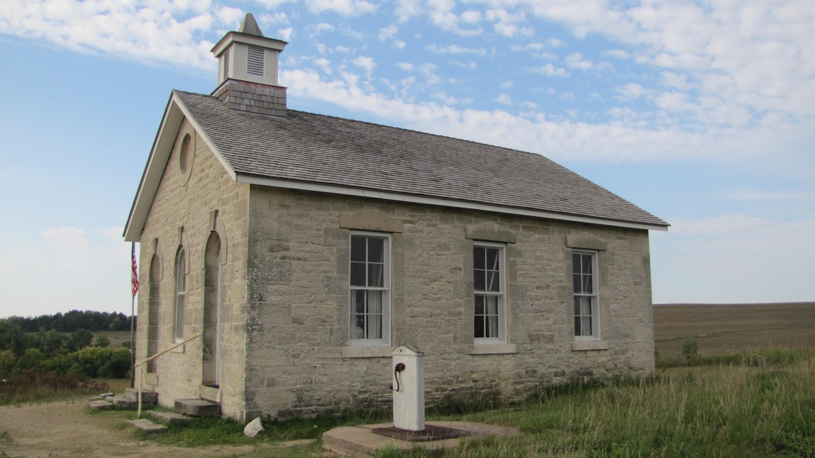 Lower Fox Creek School built of limestone with a wooden shake shingle roof and bellfry