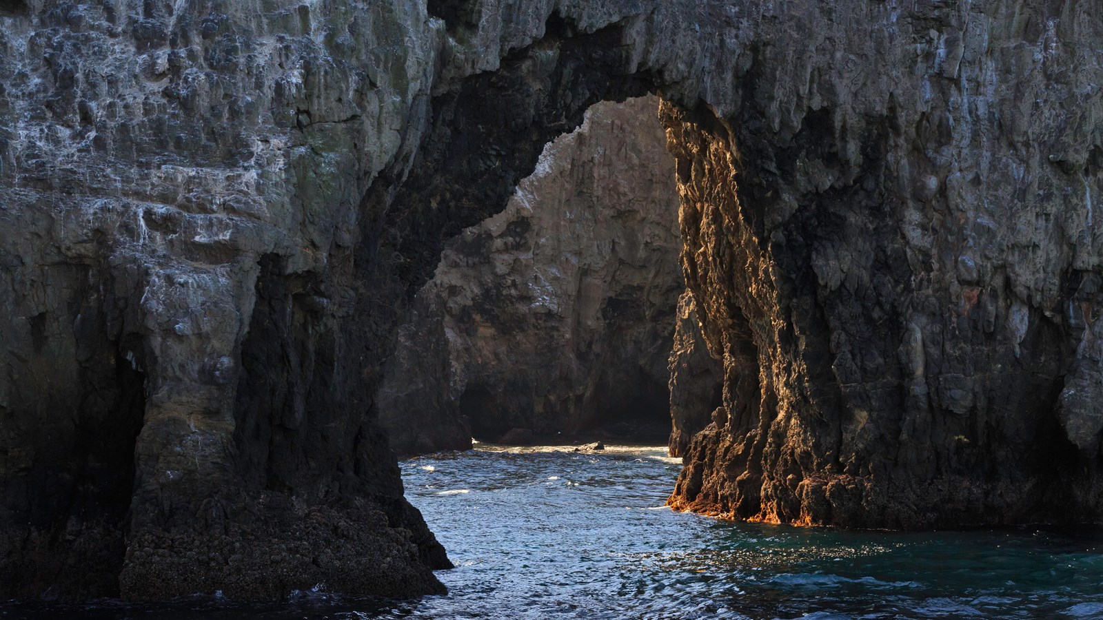 a rock arch over the ocean.