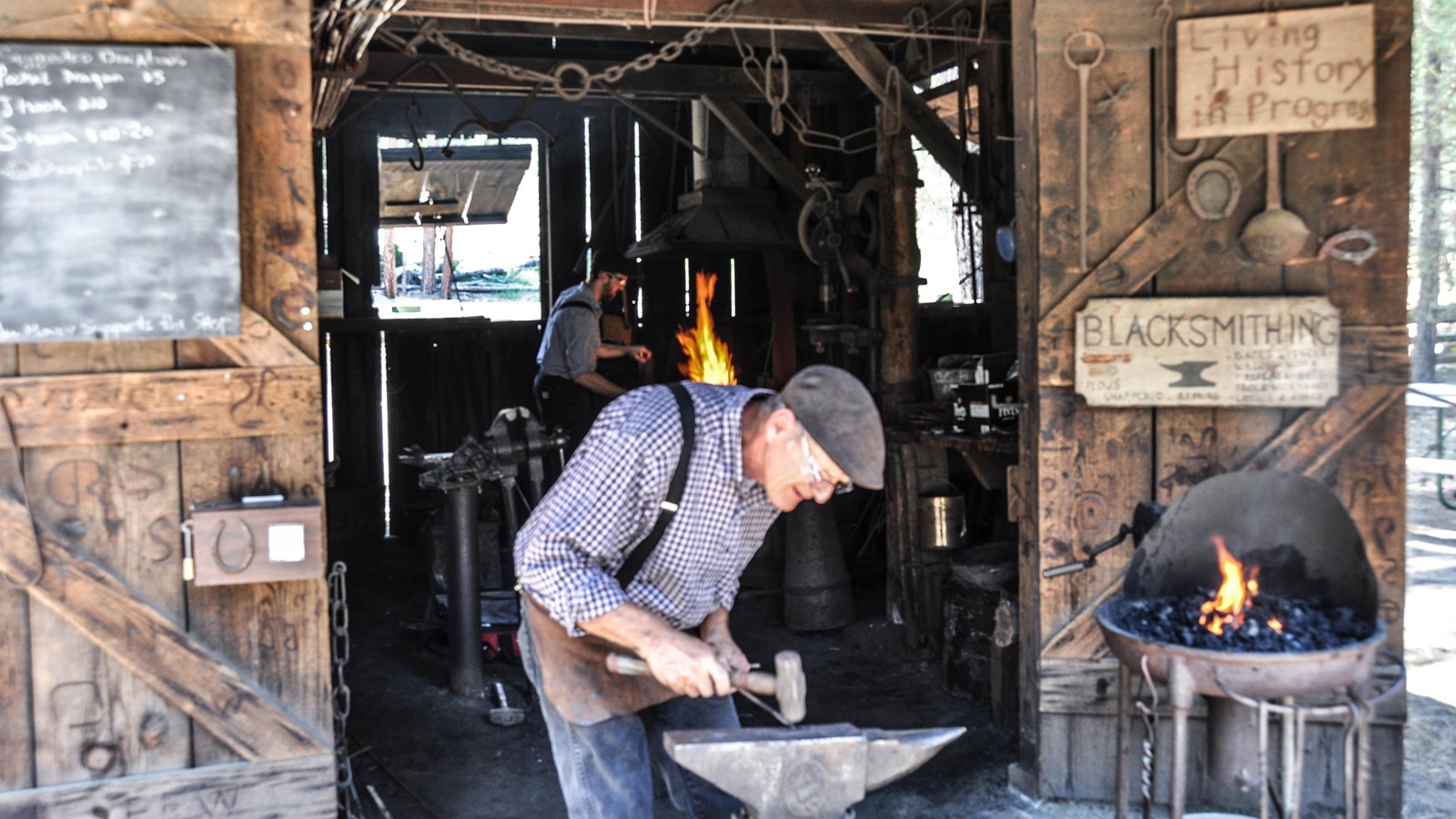 Blacksmith shop with person actively working with a mallet