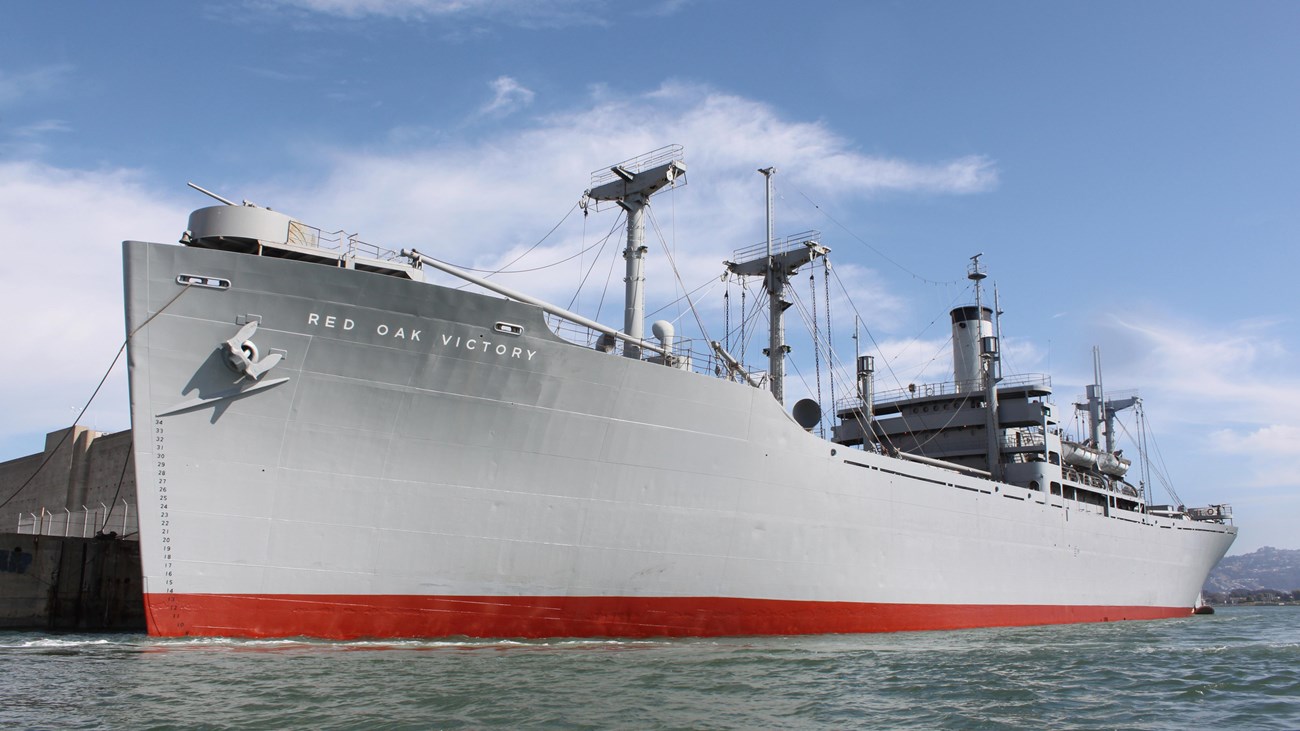 Large WWII ship sitting at dock. 