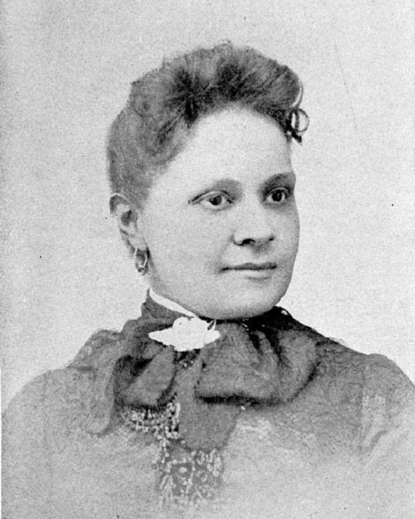 Fannie Barrier Williams, a Black woman wearing a lacy blouse with a decorative necktie tied in bows.