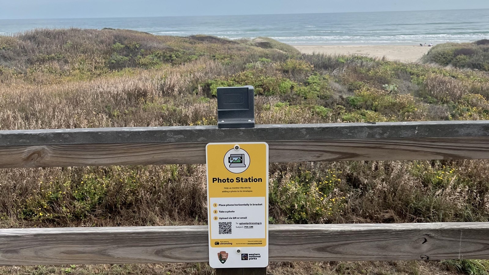 A photos station attached to a wooden railing.