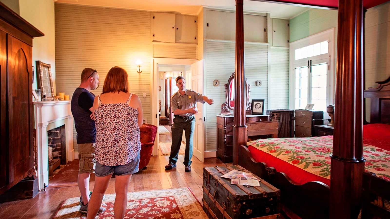 A ranger and two visitors stand in the parents\' room.