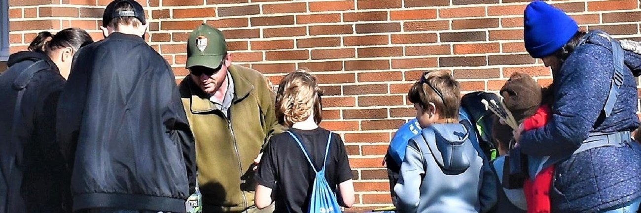 A ranger at a table outside with families